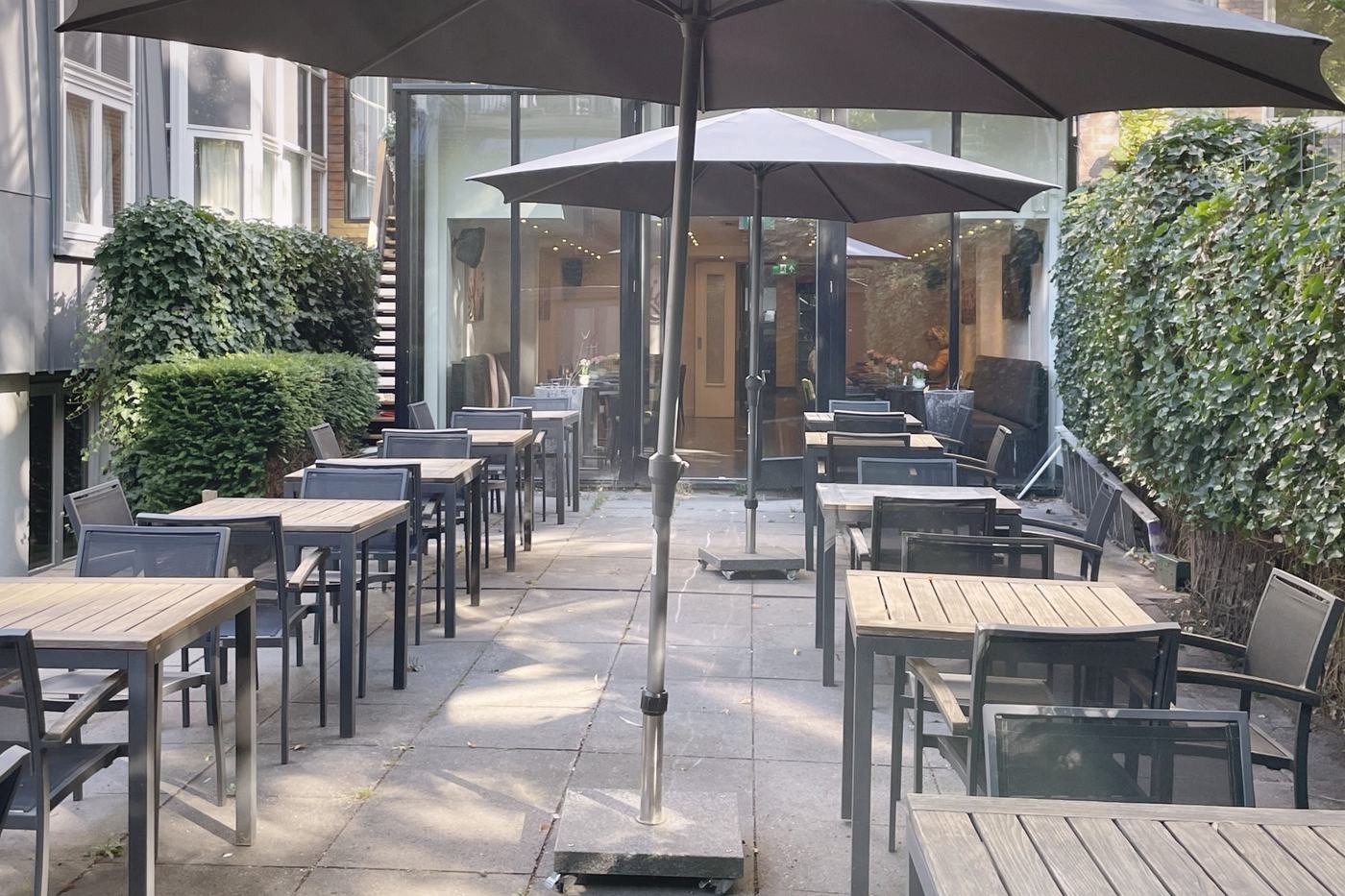 De tuin van Tulpenhof, met tafels onder de parasols
